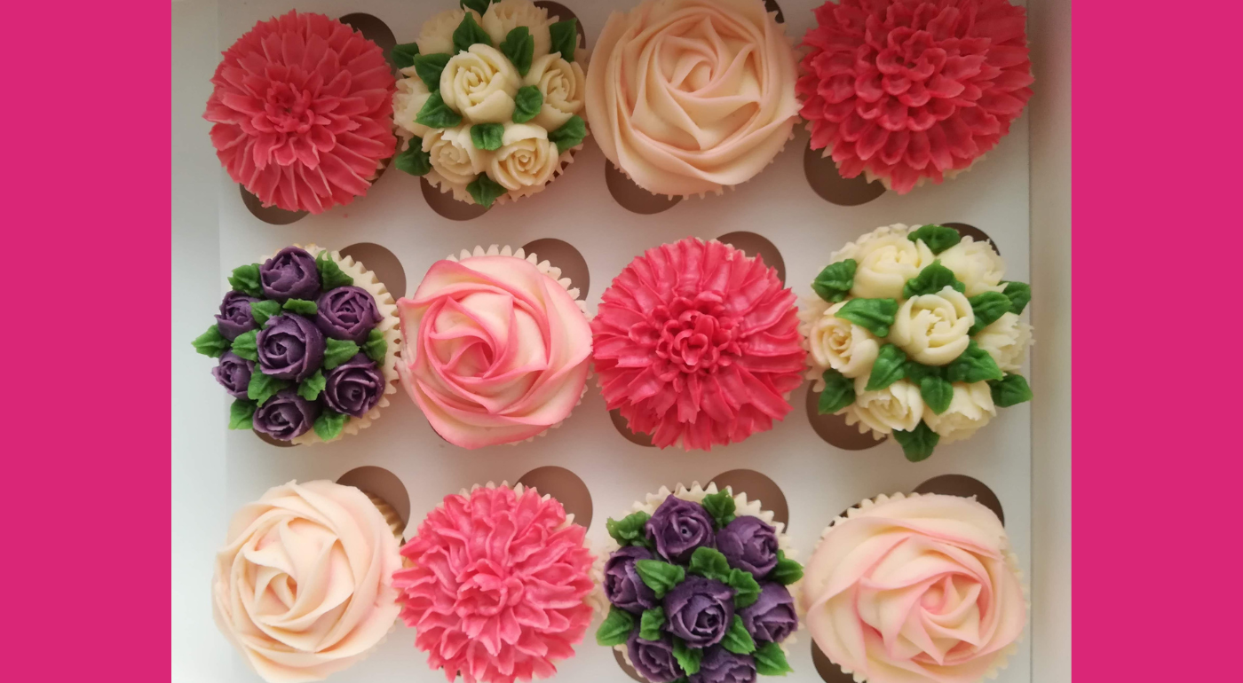 Twelve cupcakes in a box, decorated as flowers - purple and white spray roses, blush roses and pink chrysanthemums